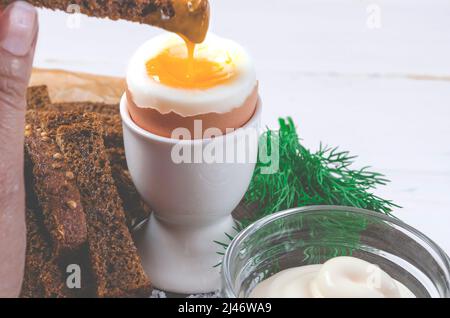 Petit-déjeuner anglais avec œufs durs et croûtons sur fond de bois blanc Banque D'Images