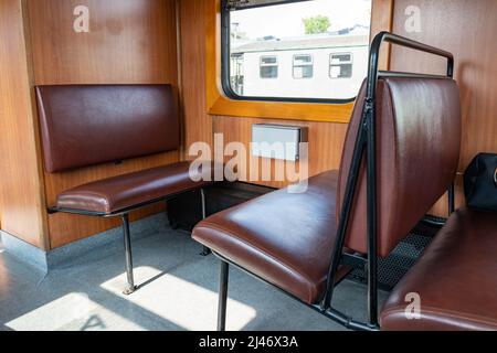 Siège dans une ancienne voiture rétro de la SDG Lößnitzgrundbahn. Intérieur d'un train de vapeur à voie étroite. Le mode historique de transport comme attraction. Banque D'Images