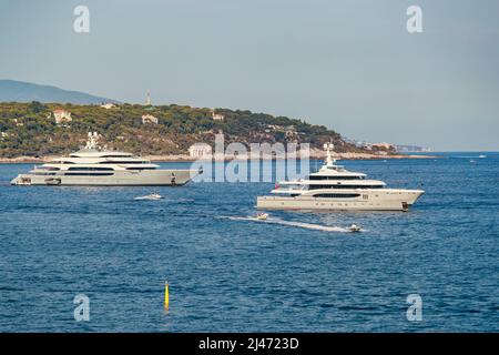 Les deux immenses yachts sont amarrés en mer par temps ensoleillé, la main courante chromée, le soleil se réfléchit sur le panneau brillant du bateau à moteur Banque D'Images