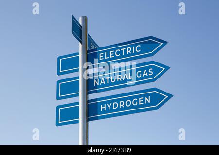 Concept d'énergie alternative du véhicule. Électricité, gaz naturel, hydrogène mots sur le poteau de signalisation isolé sur le ciel bleu Banque D'Images
