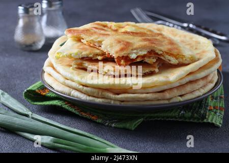 Ronds de gâteaux de khachapuri faits maison avec du fromage, frits dans une poêle. Cuisine géorgienne traditionnelle Banque D'Images