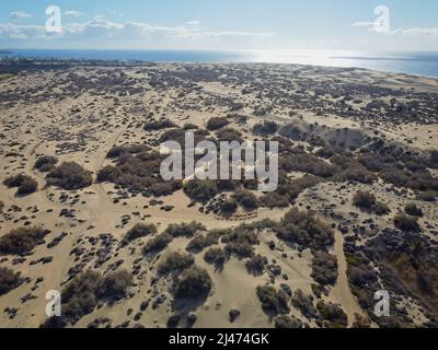 Image de drone aérien d'une ligne de chameaux lors d'un safari sur les dunes de sable du désert à Maspalomas, Grande Canarie, îles Canaries, Espagne. Banque D'Images