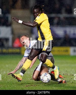 L’Oumar Niasse de Burton Albion combat avec Max Power de Wigan Athletic lors du match de la Sky Bet League One au stade Pirelli, Burton. Date de la photo: Mardi 12 avril 2022. Banque D'Images