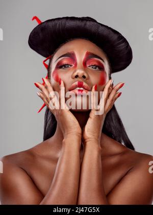 Une reine est une reine où que vous soyez. Photo en studio d'une belle jeune femme portant un maquillage asiatique sur fond gris. Banque D'Images