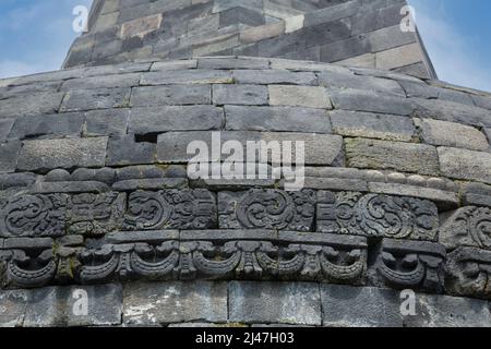 Borobudur, à Java, en Indonésie. Sculpture relief en pierre autour de la base de la plus grande Stupa du Temple. Banque D'Images