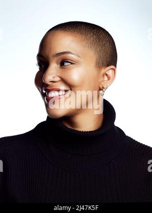 Je suis heureux dans ma propre peau. Photo en studio d'une jeune femme attrayante posant sur un fond gris. Banque D'Images