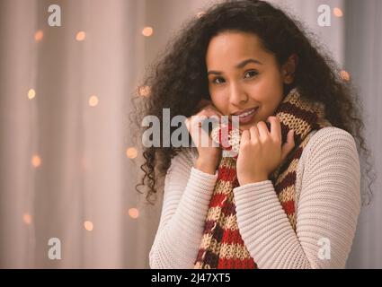 Il n'y a pas plus de cozier que Noël. Portrait d'une jeune femme portant un foulard pendant Noël à la maison. Banque D'Images