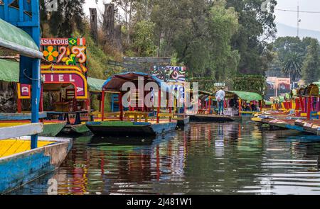 MEXICO - 19 décembre 2021. Bateaux colorés garés sur un canal dans les jardins flottants de Xochimilco au Mexique. Banque D'Images