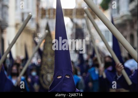 Cadix, Espagne. 13th avril 2022. Les pénitents marchent pendant une procession alors qu'ils célèbrent le Saint mardi. Après deux ans de restrictions de voyage Covid-19 et d'annulations en Espagne, elle pourrait reprendre ses activités célébrant la semaine sainte. Crédit : SOPA Images Limited/Alamy Live News Banque D'Images