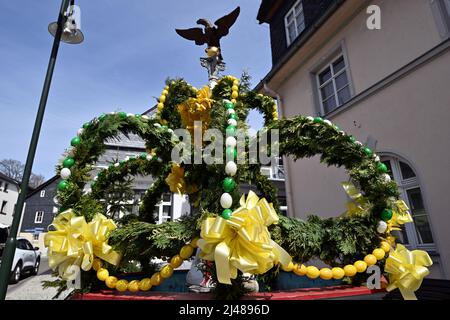 Lehesten, Allemagne. 12th avril 2022. Magnifiquement décorée comme une fontaine de Pâques est la fontaine du marché à côté de l'hôtel de ville. De nombreuses communautés décorent les fontaines de la semaine sainte avec des œufs peints, de la verdure fraîche, des fleurs et des rubans colorés. Les plantes sont supposées symboliser le réveil de la nature, les rubans représentent la joie de vivre. Credit: Martin Schutt/dpa/Alay Live News Banque D'Images