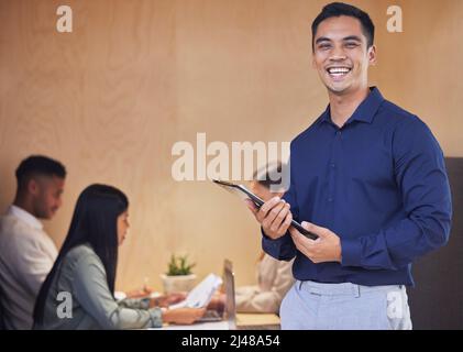 Démarons cette réunion. Portrait court d'un beau jeune homme d'affaires debout avec une planchette à pince dans la salle de réunion avec ses collègues dans la Banque D'Images