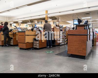 Woodinville, WA USA - vers avril 2022 : vue inclinée des caissiers à leurs caisses, attendant les clients dans une épicerie fraîche Haggen Northwest. Banque D'Images