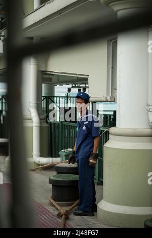 Un employé du quai observe les passagers à bord du Star Ferry à l'embarcadère central 7 de l'île de Hong Kong, 2007 Banque D'Images