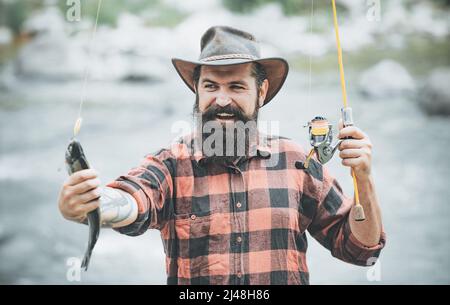 Attraper un gros poisson avec un poteau de pêche. Poisson sur le crochet. Pêche à la mouche. Tenue de truite brune. Pêche à la bobine. Concepts de réussite Banque D'Images