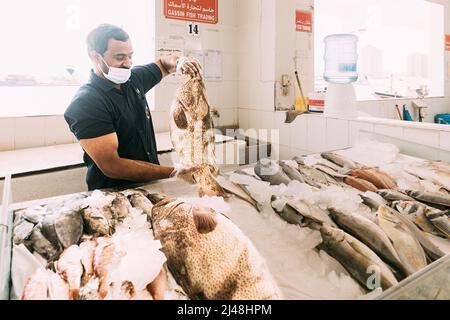 Ajman, eau, Émirats arabes Unis - 26 mai 2021 : les hommes vendent du poisson frais au marché aux poissons d'Ajman. Marché aux poissons d'Ajman. Les travailleurs au marché du poisson. Marché Banque D'Images