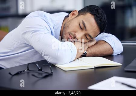 J'ai juste besoin de quelques minutes. Photo d'un homme d'affaires épuisé ayant une petite sieste sur le bureau au travail. Banque D'Images