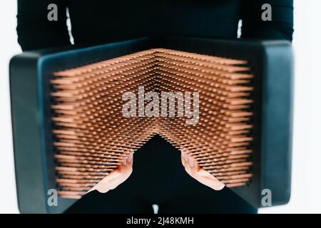 un tableau sadhu en chêne foncé avec clous en cuivre sur un plancher en bois. la pratique yogique de se tenir sur des ongles Banque D'Images