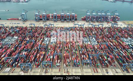 QINGDAO, CHINE - le 13 AVRIL 2022 - des navires de cargaison travaillent au terminal à conteneurs de Qianwan du port de Qingdao, dans la province de Shandong, en Chine orientale, le 13 avril 2022 Banque D'Images