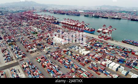 QINGDAO, CHINE - le 13 AVRIL 2022 - des navires de cargaison travaillent au terminal à conteneurs de Qianwan du port de Qingdao, dans la province de Shandong, en Chine orientale, le 13 avril 2022 Banque D'Images