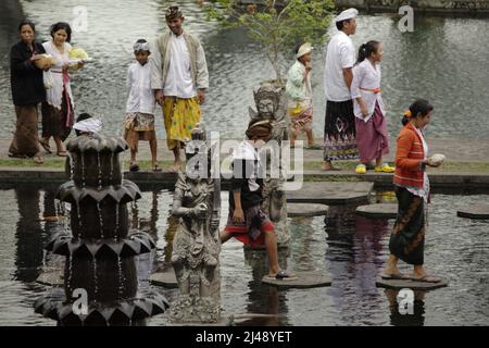 Les visiteurs marchent sur des traces de pierre au palais aquatique Tirta Gangga à Karangasem, Bali. Construit sur la base d'une croyance que l'eau est sainte, le Gangga de Tirta (tirta signifie « l'eau sainte »; Gangga fait référence au Gange en Inde) était un ancien palais royal du royaume de Karangasem. Banque D'Images