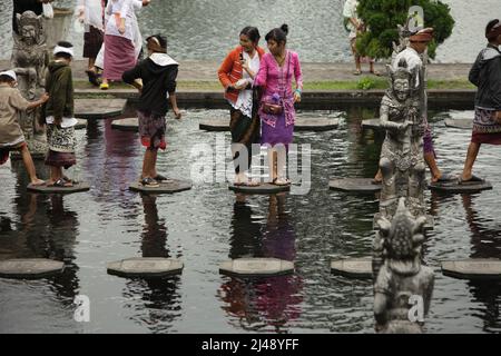 Les visiteurs marchent sur des traces de pierre au palais aquatique Tirta Gangga à Karangasem, Bali. Construit sur la base d'une croyance que l'eau est sainte, le Gangga de Tirta (tirta signifie « l'eau sainte »; Gangga fait référence au Gange en Inde) était un ancien palais royal du royaume de Karangasem. Banque D'Images