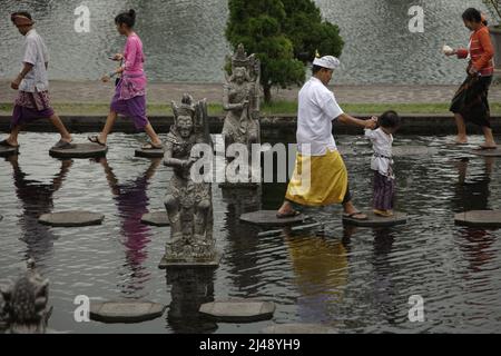 Les visiteurs marchent sur des traces de pierre au palais aquatique Tirta Gangga à Karangasem, Bali. Construit sur la base d'une croyance que l'eau est sainte, le Gangga de Tirta (tirta signifie « l'eau sainte »; Gangga fait référence au Gange en Inde) était un ancien palais royal du royaume de Karangasem. Banque D'Images