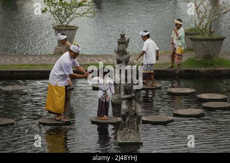 Les visiteurs marchent sur des traces de pierre au palais aquatique Tirta Gangga à Karangasem, Bali. Construit sur la base d'une croyance que l'eau est sainte, le Gangga de Tirta (tirta signifie « l'eau sainte »; Gangga fait référence au Gange en Inde) était un ancien palais royal du royaume de Karangasem. Banque D'Images