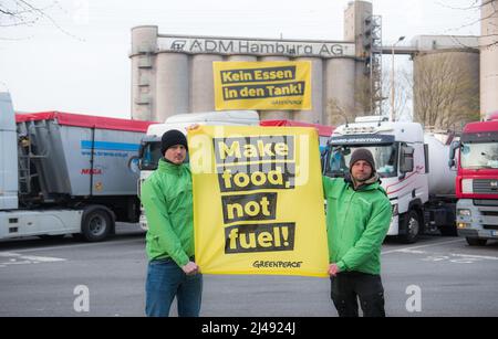 Hambourg, Allemagne. 13th avril 2022. Les militants de Greenpeace se tiennent devant le site Archer Daniels Midland (ADM), dans le quartier de Wilhelmsburg, avec une bannière qui se lit comme suit : « faire de la nourriture, pas du carburant », pour protester contre la production de biocarburants avec de la nourriture. Credit: Daniel Bockwoldt/dpa/Alay Live News Banque D'Images