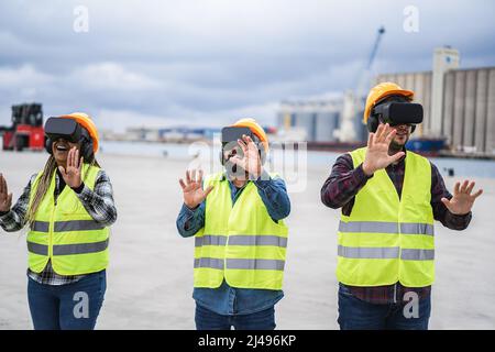 Travailleurs multiraciaux utilisant des micro-casques de réalité virtuelle au terminal industriel Port - concentrez-vous sur les lunettes de protection pour homme droit Banque D'Images