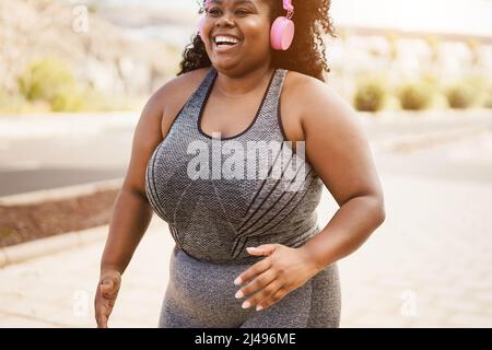 Sport curvy femme africaine jogging en extérieur - Focus sur le visage Banque D'Images