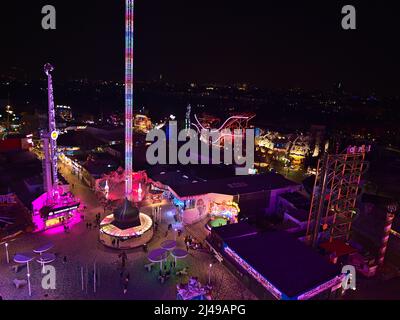 Vue aérienne stupéfiante sur le parc d'attractions éclairé de Wurstelprater la nuit à Vienne, Autriche, avec tours et montagnes russes. Banque D'Images