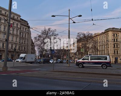 Vue sur la place animée Schwarzenbergplatz dans le centre de Vienne, Autriche en soirée avec parking de police entouré de bâtiments historiques. Banque D'Images