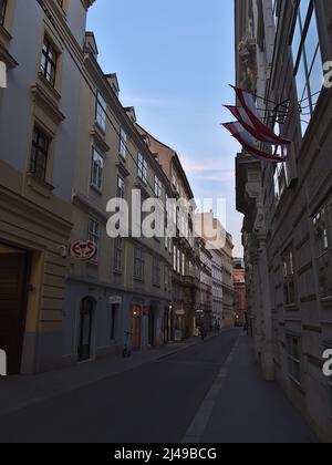 Diminution de la perspective de la ruelle étroite Himmelpfortgasse dans le centre historique de Vienne, Autriche dans la soirée avec des magasins dans des bâtiments historiques. Banque D'Images