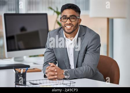Je suis si heureux de mener une carrière réussie. Portrait d'un jeune homme d'affaires travaillant dans un bureau. Banque D'Images