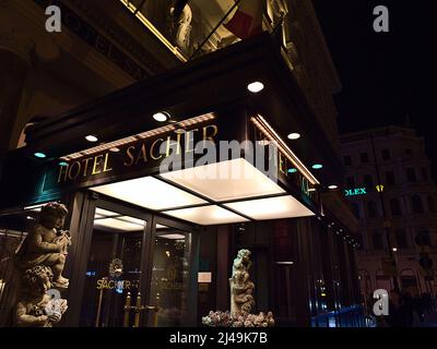 Vue de l'entrée du bâtiment du célèbre hébergement de luxe Hôtel Sacher dans le centre historique de Vienne, Autriche par nuit avec lettrage doré. Banque D'Images