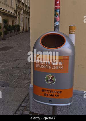 Vue sur une poubelle grise et orange dans le vieux centre de Vienne, Autriche avec texte amusant. Concentrez-vous sur les poubelles. Banque D'Images