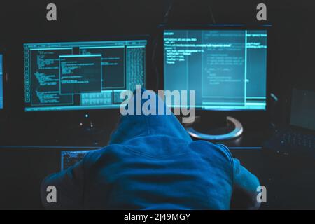 Hacker fatigué surtravaillé. hacker à capuchon dormant sur son ordinateur, logiciel de code malveillant sur le centre de données de piratage d'écran. Télécharger l'image Banque D'Images