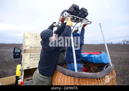 Préparations pour la montgolfière : les hommes plaçant le brûleur à gaz sur le dessus du panier. 12 janvier 2020. Kiev, Ukraine Banque D'Images