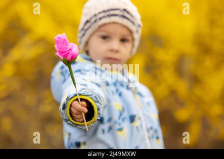 Enfant béatiful, petit garçon, tenant fleur en papier rose, fait à la main pour maman pour la fête des mères Banque D'Images
