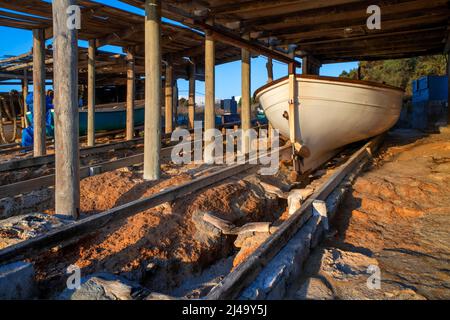 Parc de stationnement de bateaux Fisher à es Caló de San Agustí port de jetée de l'île de Formentera chemins de fer de bateaux en bois à Formentera îles Baléares Espagne Banque D'Images