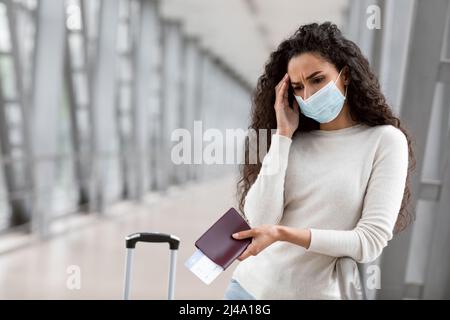 Annulation de vol. Contrarié jeune femme portant un masque médical attendant à l'aéroport Banque D'Images