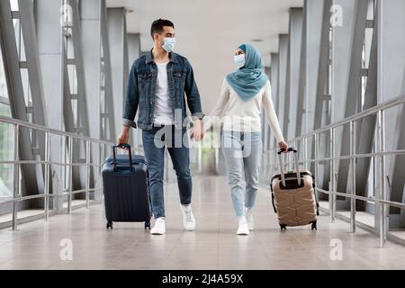 Portrait d'un couple musulman heureux en masques médicaux voyageant ensemble pendant une pandémie Banque D'Images