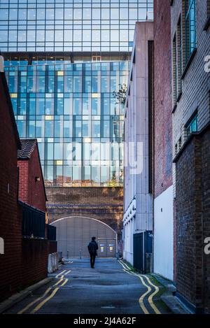 Rue dans une ancienne zone industrielle avec une ancienne arche de brique et un bâtiment moderne de bureau en verre au-delà, London Borough of Southwark, Londres, Angleterre, Royaume-Uni Banque D'Images