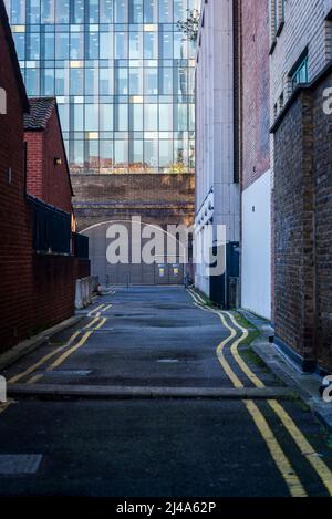 Rue dans une ancienne zone industrielle avec une ancienne arche de brique et un bâtiment moderne de bureau en verre au-delà, London Borough of Southwark, Londres, Angleterre, Royaume-Uni Banque D'Images