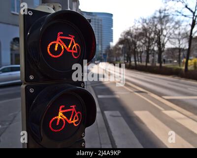 Vue rapprochée du feu rouge pour bicyclettes sur une piste cyclable à côté d'une route dans le centre de Vienne, Autriche, par beau temps. Banque D'Images