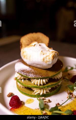 Une pile de crêpes avec du thé matcha servi dans une assiette sur la table dans un restaurant. Banque D'Images