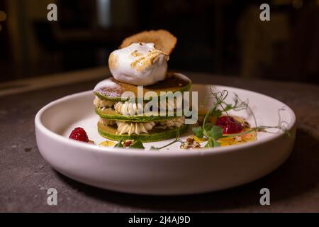 Une pile de crêpes avec du thé matcha servi dans une assiette sur la table dans un restaurant. Banque D'Images