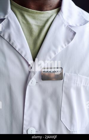 Gros plan d'un spécialiste médical africain portant un badge sur son manteau blanc Banque D'Images