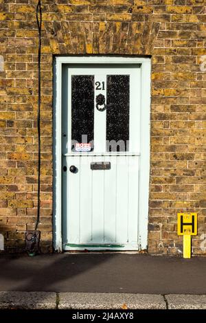 Une ancienne porte de village en bois avec des meubles de porte et un numéro 21. Un panneau ne demandant pas de courrier indésirable. Briqueteries de l'époque victorienne. Banque D'Images