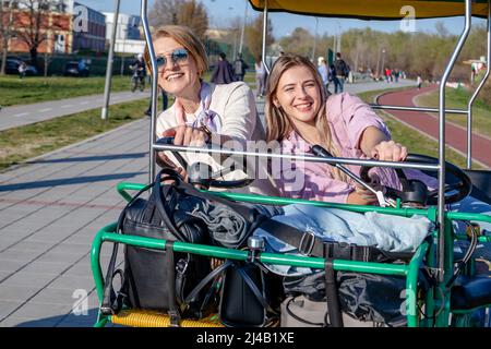 Mère et fille qui s'amusent à monter sur une promenade à vélo en tandem ou un quadricycle avec un volant. Banque D'Images